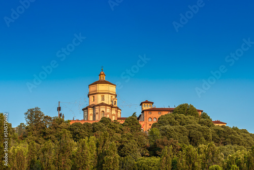 View of Santa Maria del Cappuccini Church on top of a hill surrounded by trees in Po riverbank Turin Italy