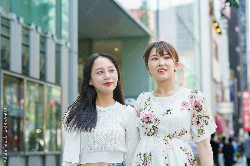 Fototapeta premium 都会で友達とショッピングする女性