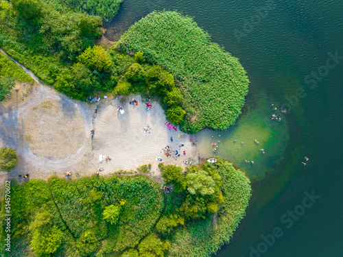 Summer time at the lake. Rest on the beach. Aerial view of small hidden beach.