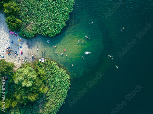 Fototapeta Naklejka Na Ścianę i Meble -  Summer time at the lake. Rest on the beach. Aerial view of small hidden beach.