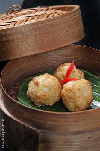 Fried meatball dimsum, served in a round bamboo container. Typical traditional Chinese dimsum serving container