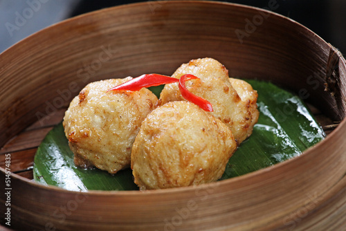 Fried meatball dimsum, served in a round bamboo container. Typical traditional Chinese dimsum serving container