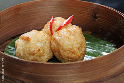 Fried meatball dimsum, served in a round bamboo container. Typical traditional Chinese dimsum serving container
