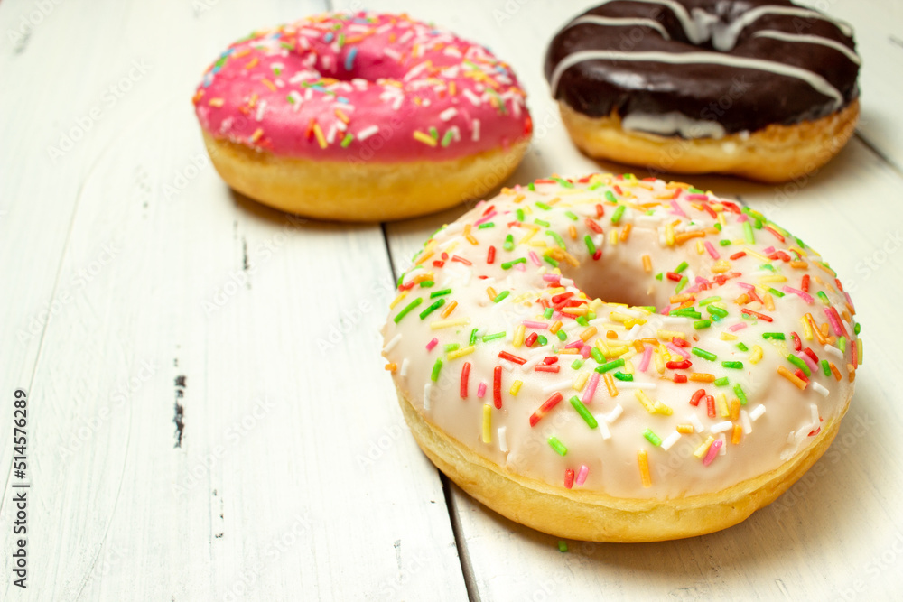 donuts of different colors on a white table