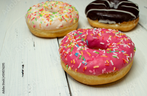 donuts of different colors on a white table