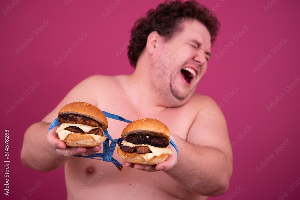 Diet, fitness and healthy lifestyle. Funny fat man eating a burger