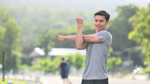 Fitness young asian man in sportswear warming up before jogging in the morning