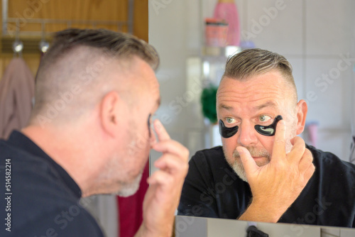 Man applying a cosmetic gel hydration patch