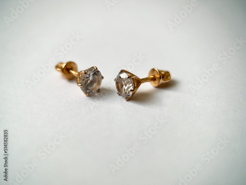 Gold stud earrings with cubic zirconia close-up © yarm_sasha
