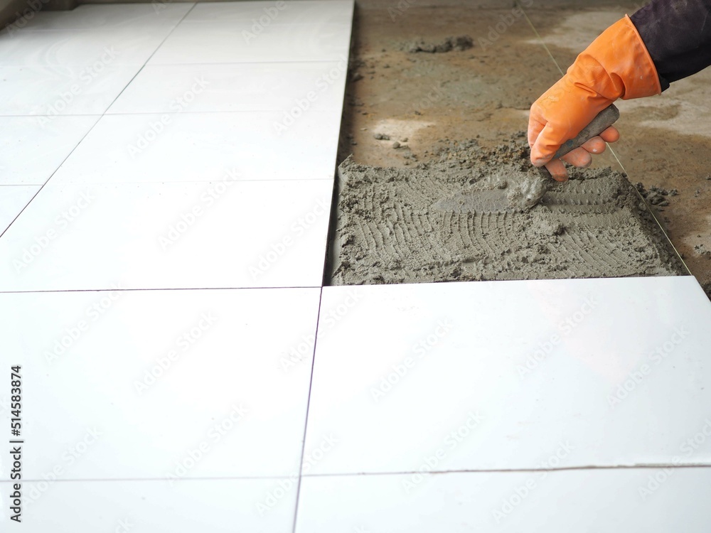 Laying floor ceramic tile. construction workers laying tile over