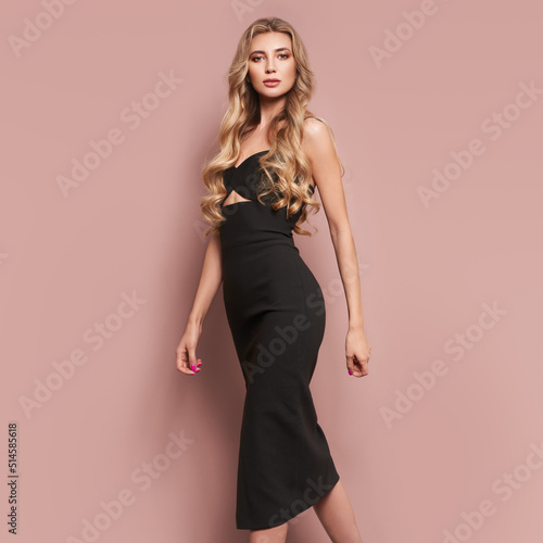 Portrait of gorgeous elegant sensual blonde woman wearing fashion black dress isolated on beige background Fototapet