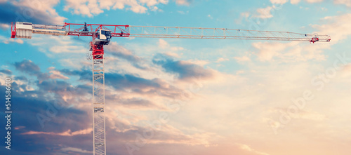 Print op canvas A red and white tower crane on a dramatic sky background with a space for text