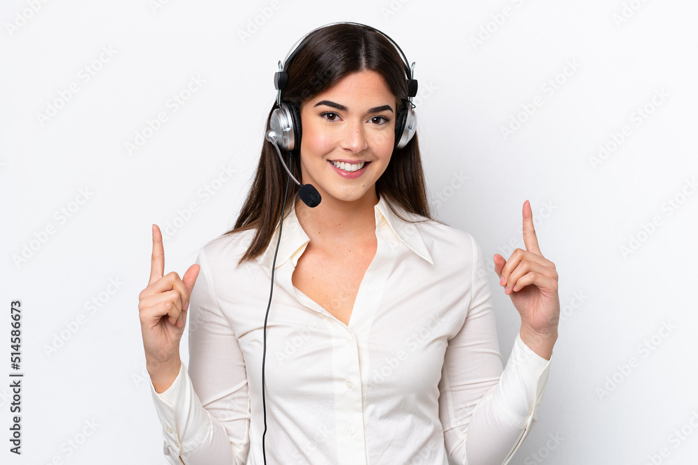 Telemarketer caucasian woman working with a headset isolated on white background pointing up a great idea Telemarketer caucasian woman working with a headset isolated on white background pointing up a great idea