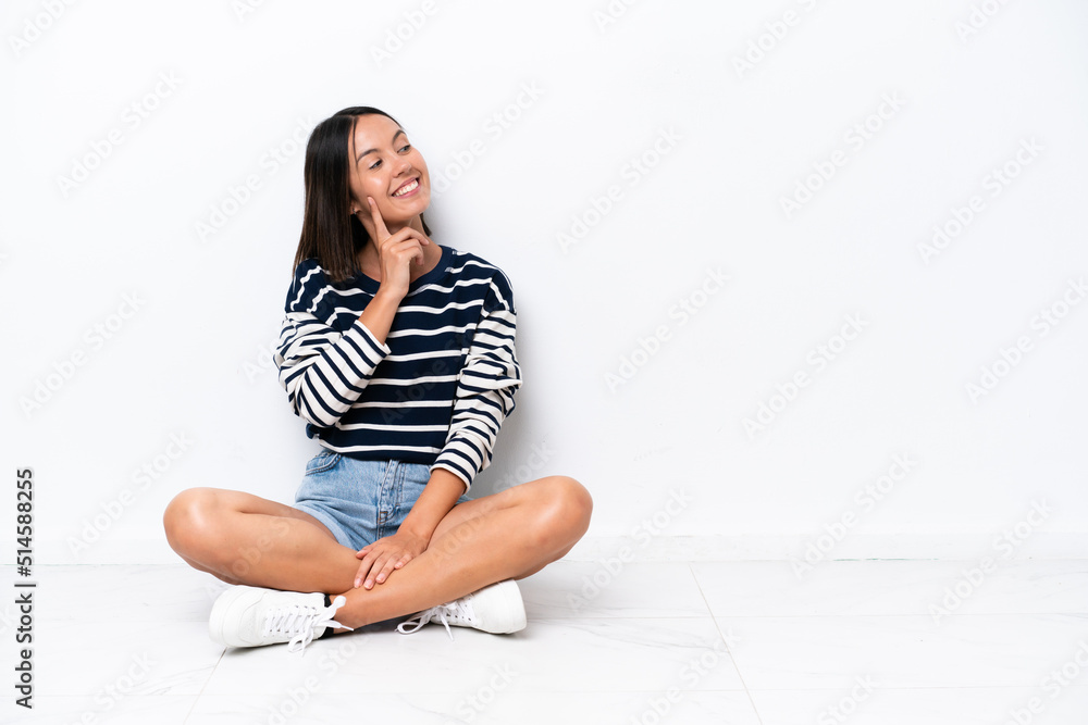 Young caucasian woman sitting on the floor isolated on white background thinking an idea while looking up Young caucasian woman sitting on the floor isolated on white background thinking an idea while looking up