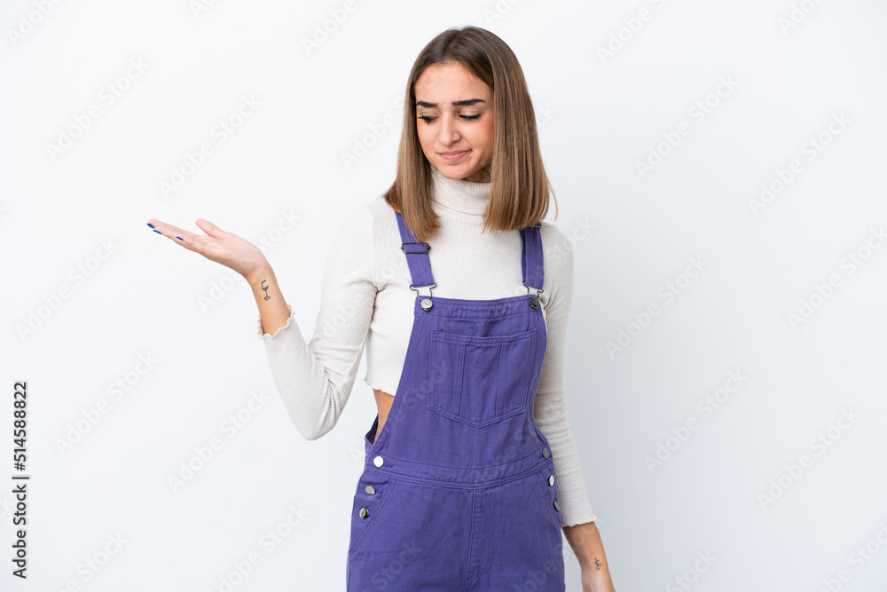 Young caucasian woman isolated on white background holding copyspace with doubts Young caucasian woman isolated on white background holding copyspace with doubts