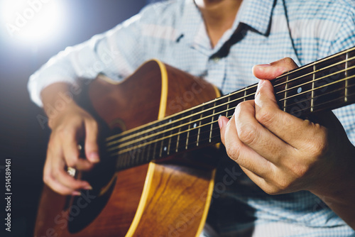Closeup of hand playing acoustic guitar