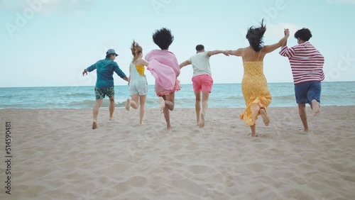 roup of friends having fun on the beach. Multiethnic Teenagers having a good time during the summer celebrating together next to the ocean. photo