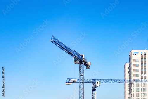 Tower cranes on the residential building construction site on blue sky	