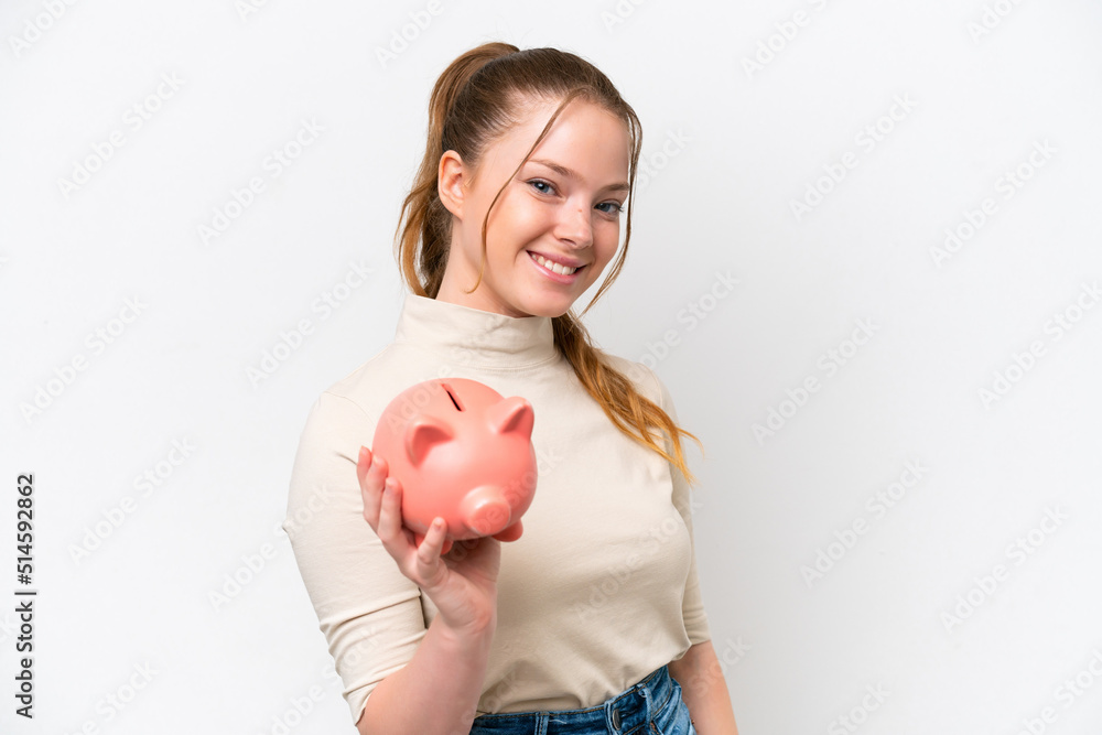 Young caucasian girl holding a piggybank isolated on white background with happy expression Young caucasian girl holding a piggybank isolated on white background with happy expression