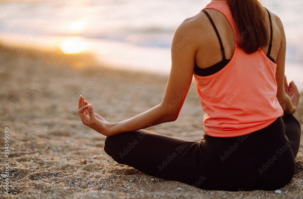 Beautiful woman doing yoga near the ocean barefoot. Young woman in sportswear doing fitness exercise on the beach. Calmness and balance, a healthy lifestyle. Beautiful woman doing yoga near the ocean barefoot. Young woman in sportswear doing fitness exercise on the beach. Calmness and balance, a healthy lifestyle.