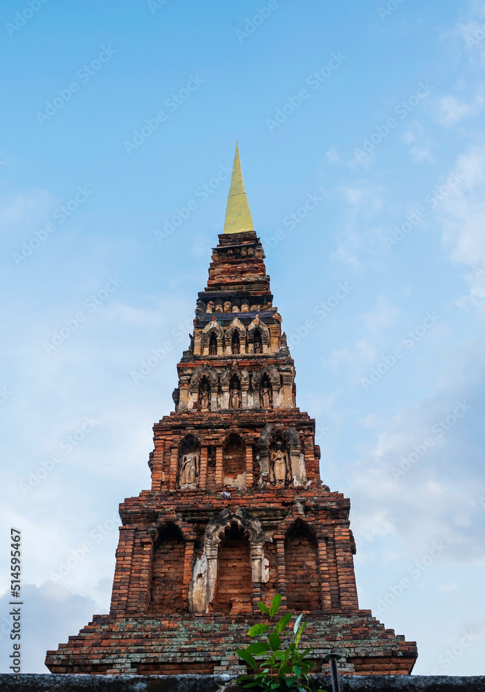 Ancient brick pagoda in Lamphun province against blue sky