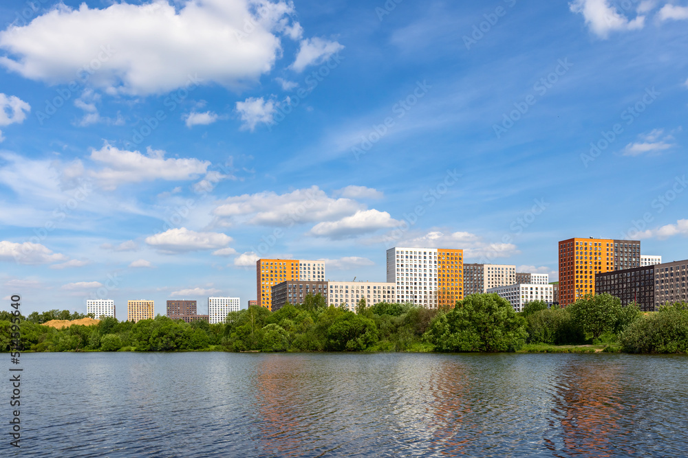 New modern residential apartment buildings district near the lake surrounded by green trees