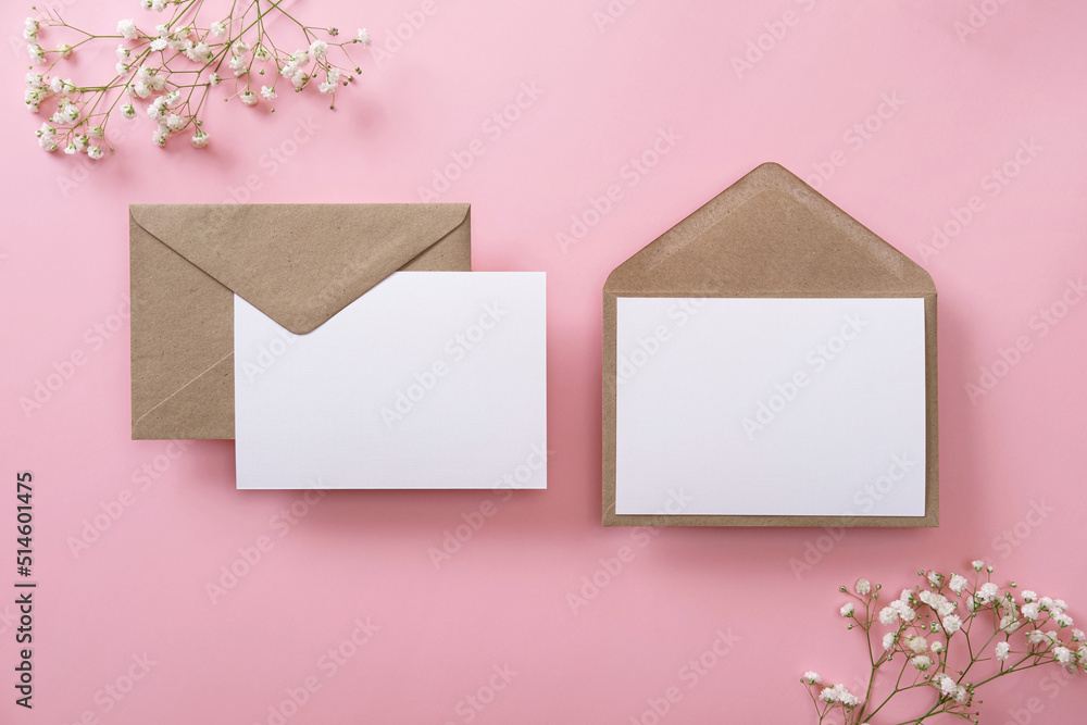 Blank greeting cards and envelopes with gypsophila on pink background. Blank paper sheet cards with mockup copy space. Minimal workplace composition. Flat lay, top view Blank greeting cards and envelopes with gypsophila on pink background. Blank paper sheet cards with mockup copy space. Minimal workplace composition. Flat lay, top view