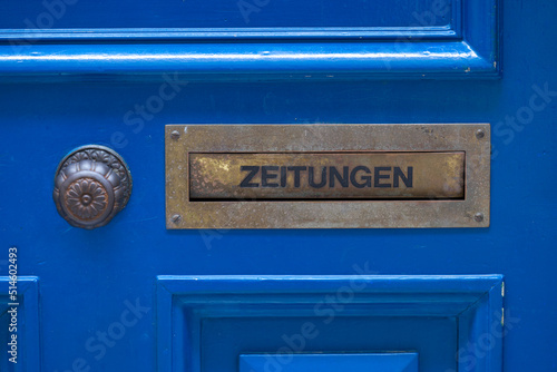 Wallpaper Mural Close-up of blue wooden door with mail slot and text Zeitungen (German, translation is newspapers) on a cloudy summer day. Photo taken June 28th, 2022, Zurich, Switzerland. Torontodigital.ca