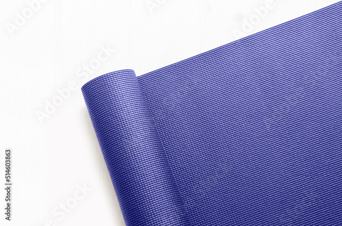 Top view of exercise mat in trend color very peri on light background. Concept for practice yoga, pilates or any physical workout.