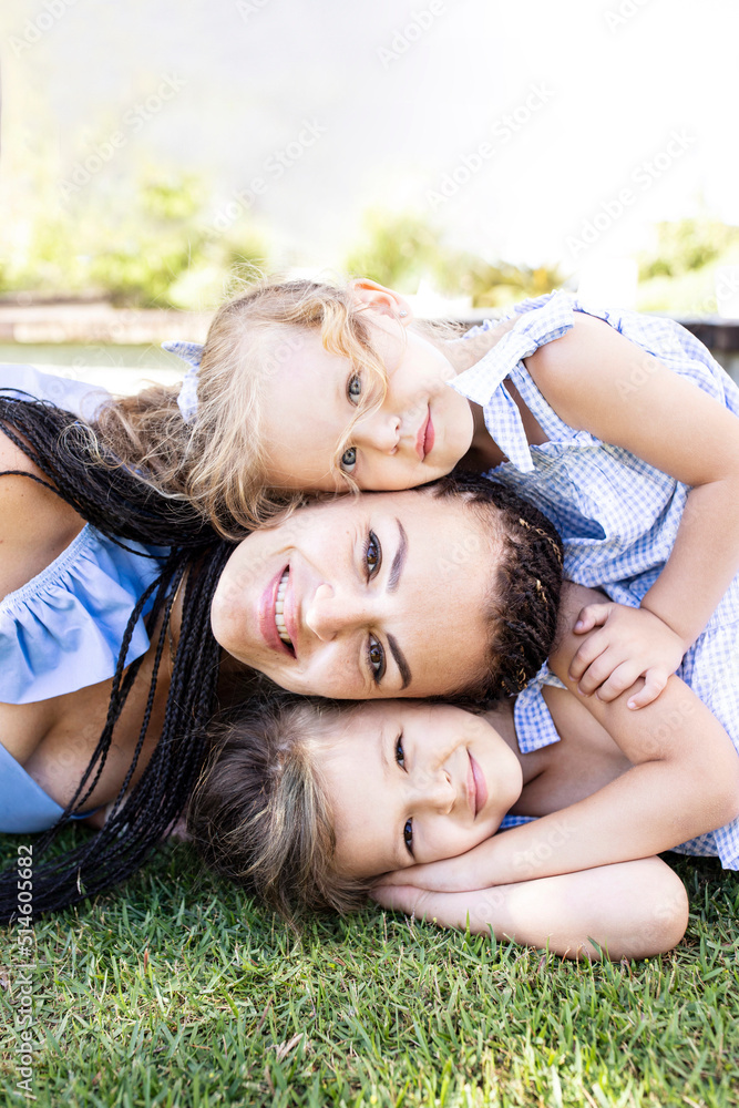 Cute portrait of mom and two daughters, heads close to each other, smiling faces. Park, outside. The concept of family, love, mother's day, children, motherhood, childhood. Caucasian people. Outdoors. Cute portrait of mom and two daughters, heads close to each other, smiling faces. Park, outside. The concept of family, love, mother's day, children, motherhood, childhood. Caucasian people. Outdoors.