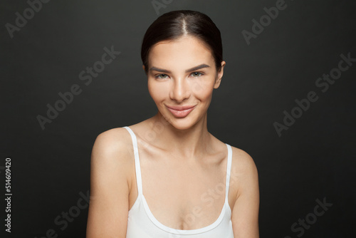 Healthy young woman smiling on black background