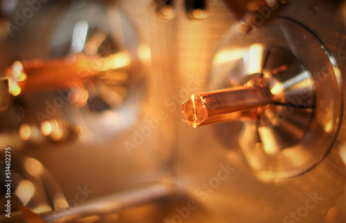 copper square bar protruding from the chuck during processing in a turning machine, red colors