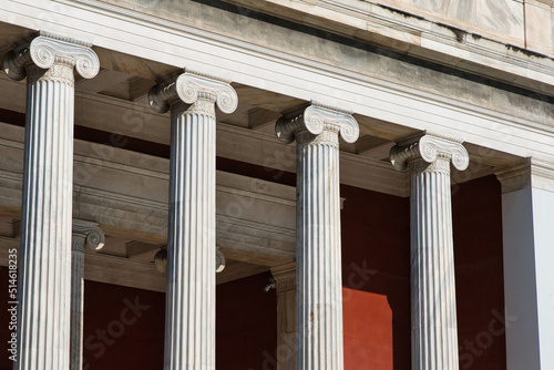 Close-up photo of big, tall columns on a traditional style greek building in Athens, Greece form the entrance area of a Museum. 