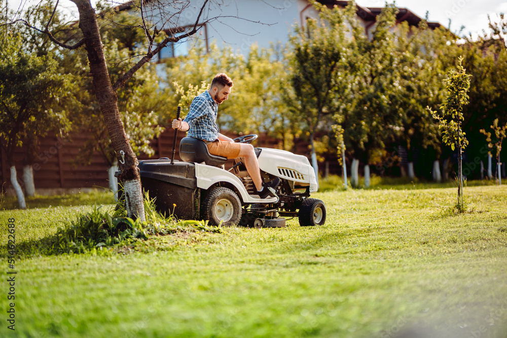industry-details-portrait-of-gardener-mowing-lawn-cutting-grass-in