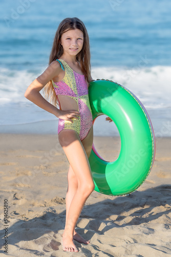 Portrait of a happy teenage girl with an inflatable rubber ring having fun on the beach.