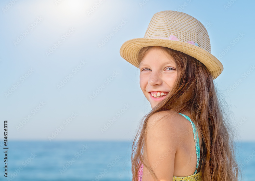 Portrait of a pretty smiling teenage girl on the background of the sea.