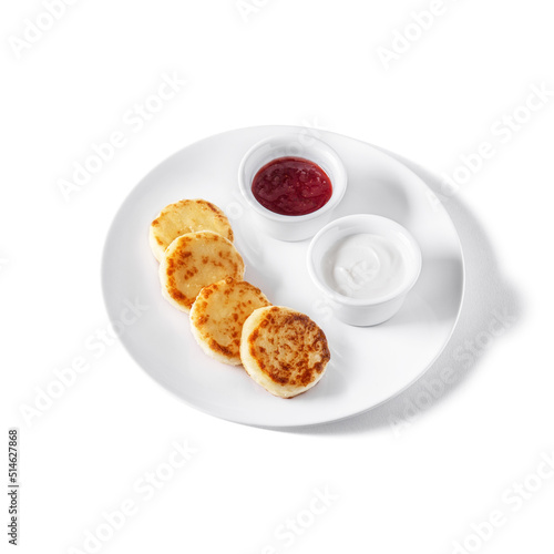 Cheese pies in a plate with sour cream and jam