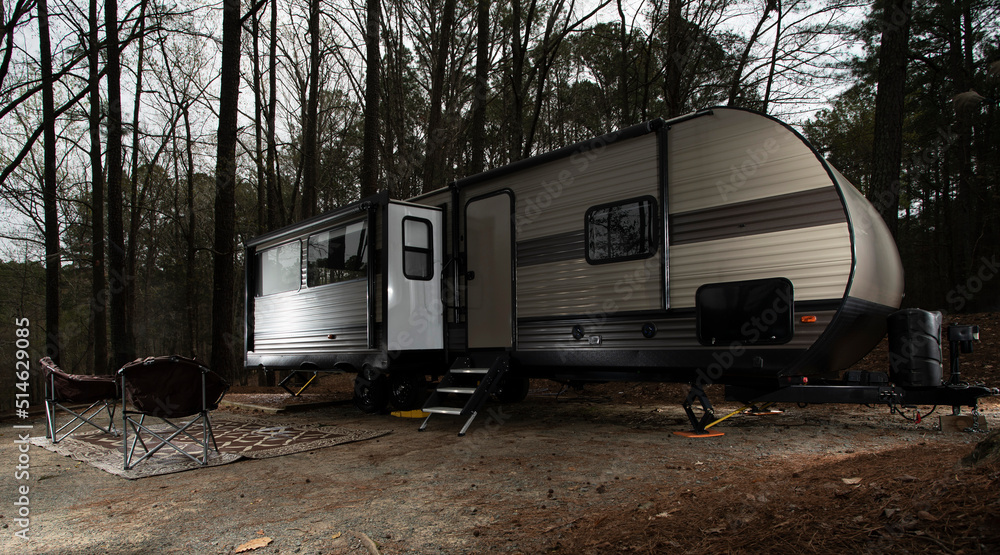 Large camping trailer in a darkeing campsite