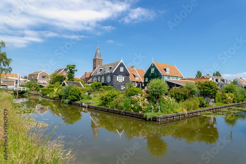 Small town village of Marken with architecture traditional houses and church under blue sky and white fluffy cloud, The municipality of Waterland in the province of North Holland, Netherlands. photo