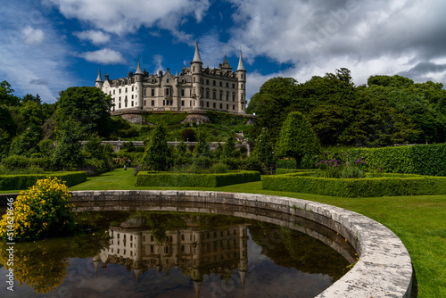 view of Dunrobin Castle and Gardens in the Scottish Highlands and castle reflection in the fountain