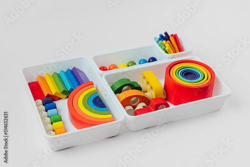 Colorful wooden toys in the colors of the rainbow in plastic box. Concept of organizing and storing children's toys. Cute kids toys to play and for decorating children's room.