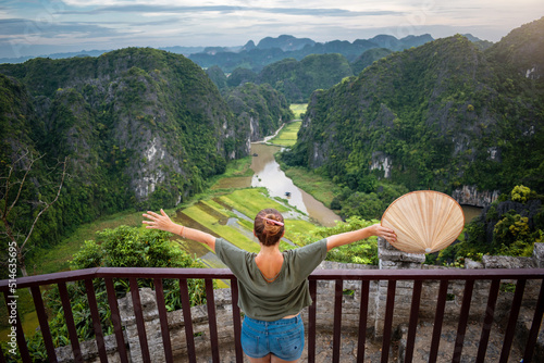 Mujer turista disfrutando bellas vistas desde famoso mirador, en Ninh Binh, Vietnam photo