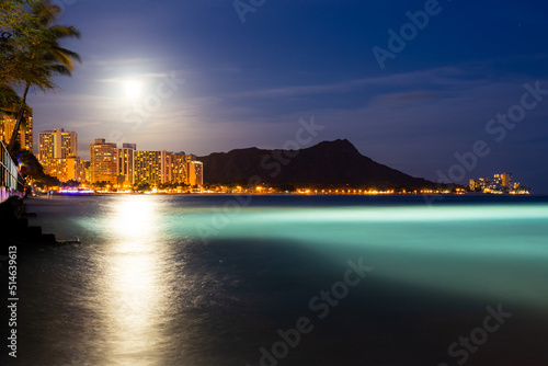 Beautiful night view of sky, diamondhead, beach, and moon in Waikiki beach, Honolulu, Hawaii