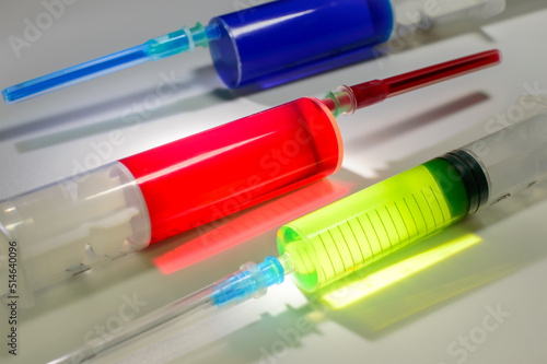 Tree medical syringes with colored paint of different colors on a white background. Vaccination against corona virus. Vaccine against monkeypox. Medical treatment. Blood test in laboratory.
