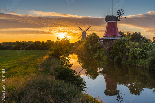 Fotobehang Die Greetsieler Zwillingsmühlen bei Sonnenuntergang; Ostfriesland; Deutschland