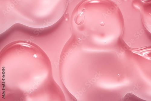 Cosmetic pink lotion transparent gel drops texture background