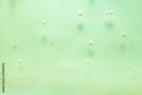 Cosmetic green lotion transparent gel drops texture background