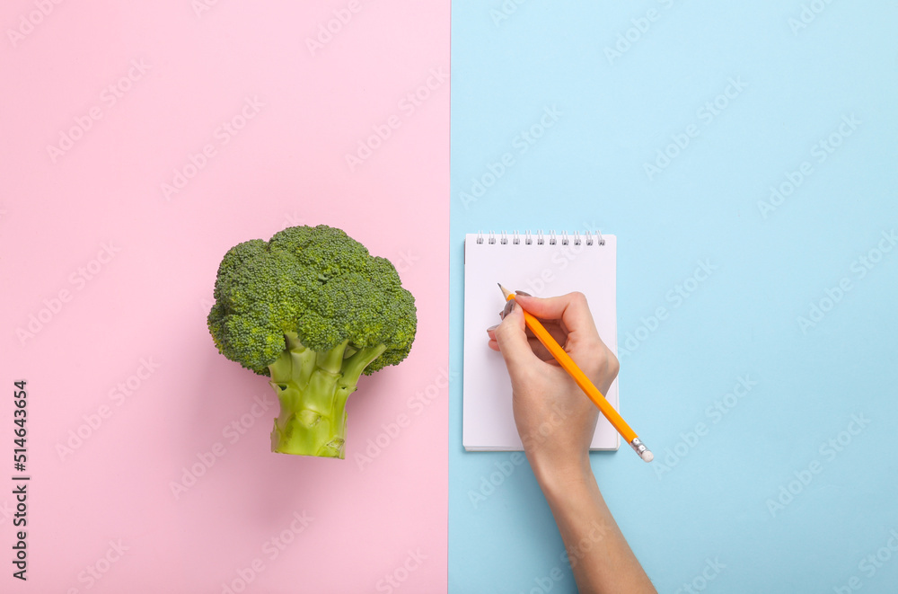 Diet plan. Broccoli, hand write on notepad on blue pink pastel background. Top view. Flat lay - obrazy, fototapety, plakaty 