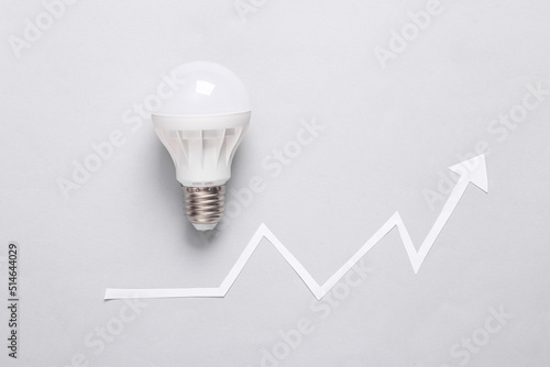 Light bulb with growth arrow on gray background