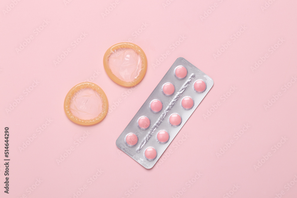 Contraceptives. Condoms and birth control pills on a pink background. Contraceptives. Condoms and birth control pills on a pink background.